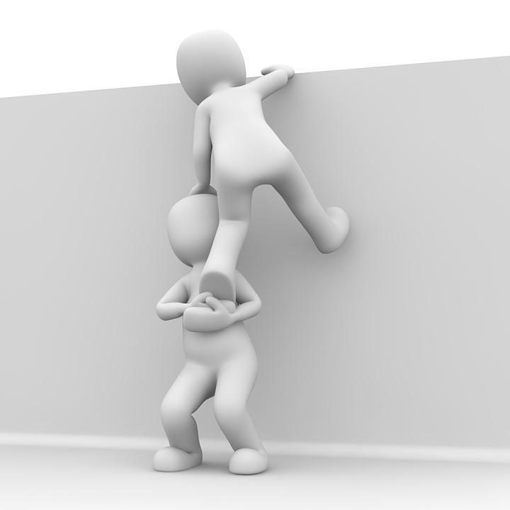 Bilden är en illustration på en person som hjälper en annan att klättra över en mur.