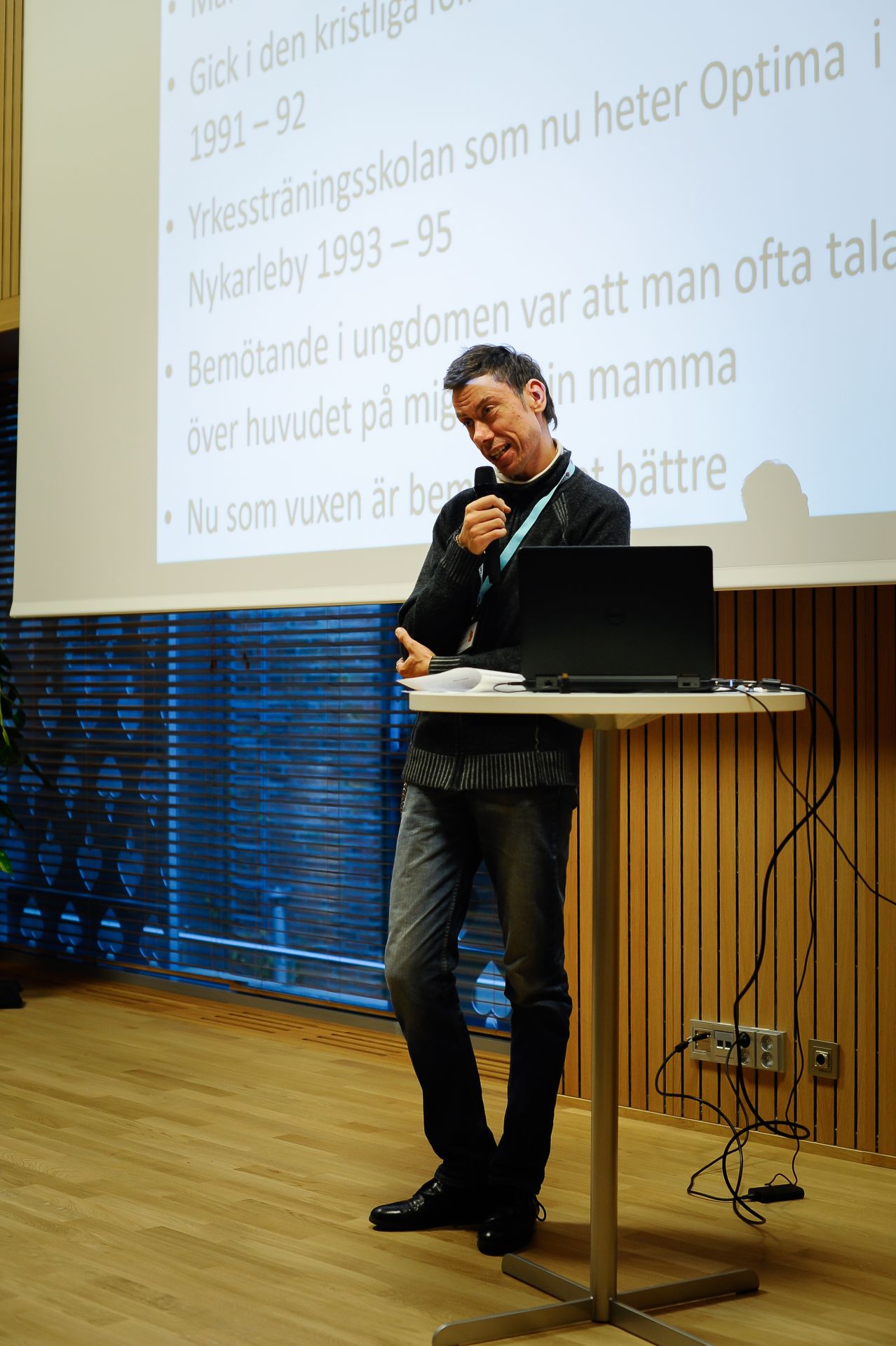 Bild på vår erfarenhetstalare Joakim Smeds som håller en presentation med en mikrofon i handen